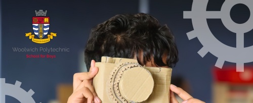 Student holding up a cardboard camera to his face